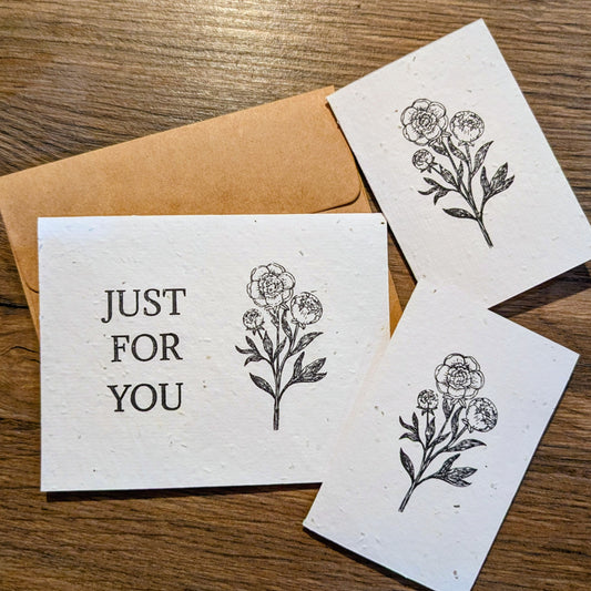 Greeting card with floral design and 'Just For You' text on a wooden surface