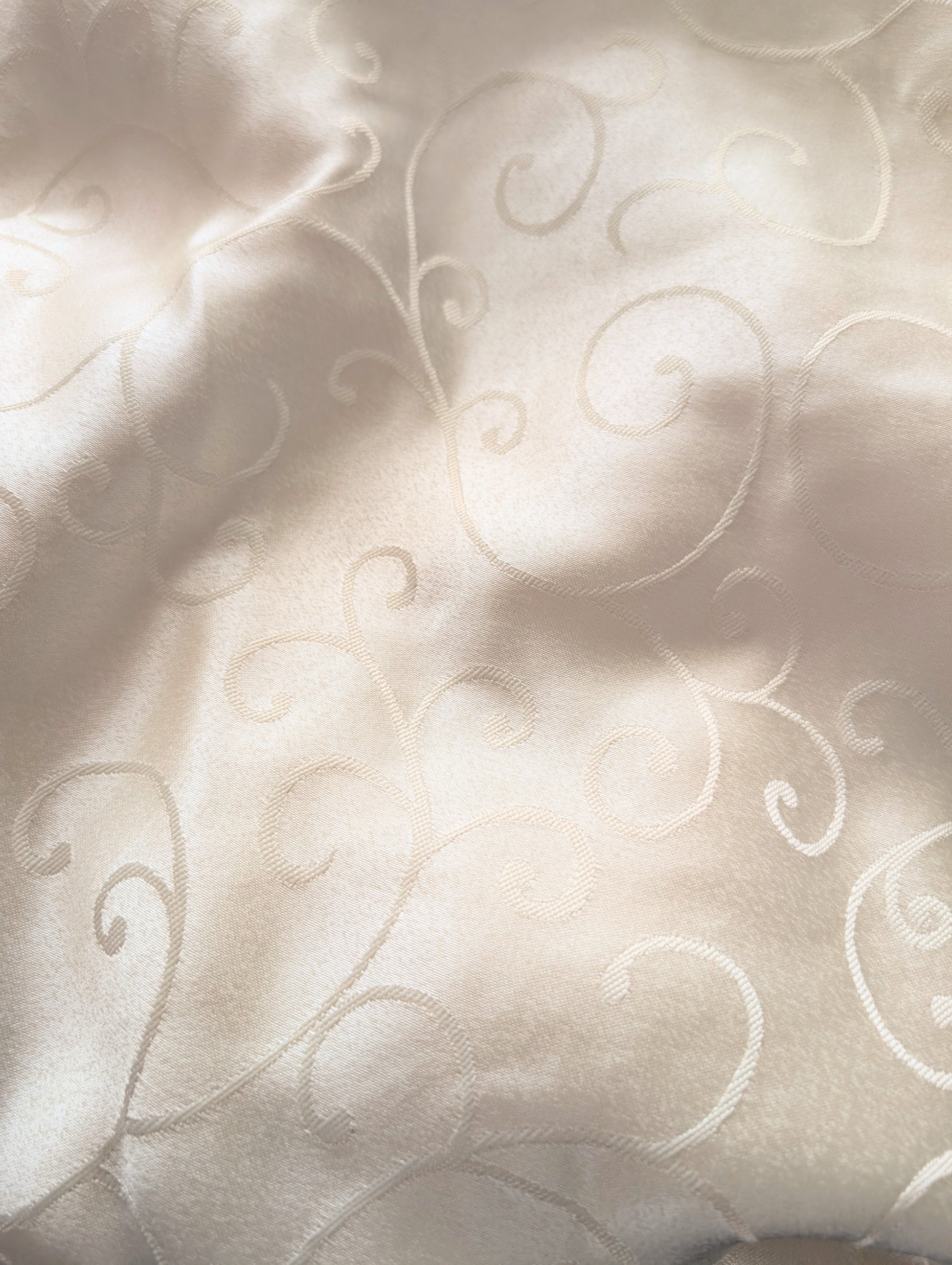 Close-up of textured fabric with intricate patterns on a light background