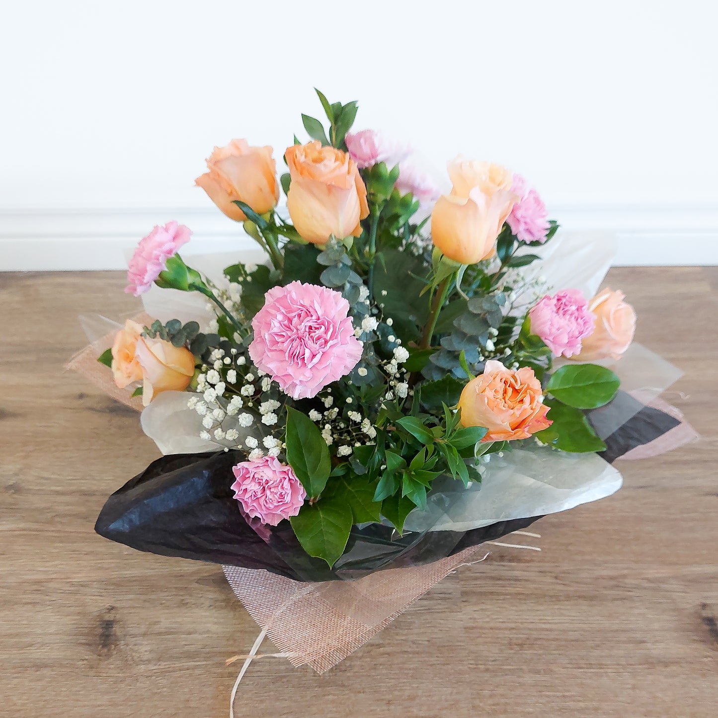 roses and carnations arranged in a box
