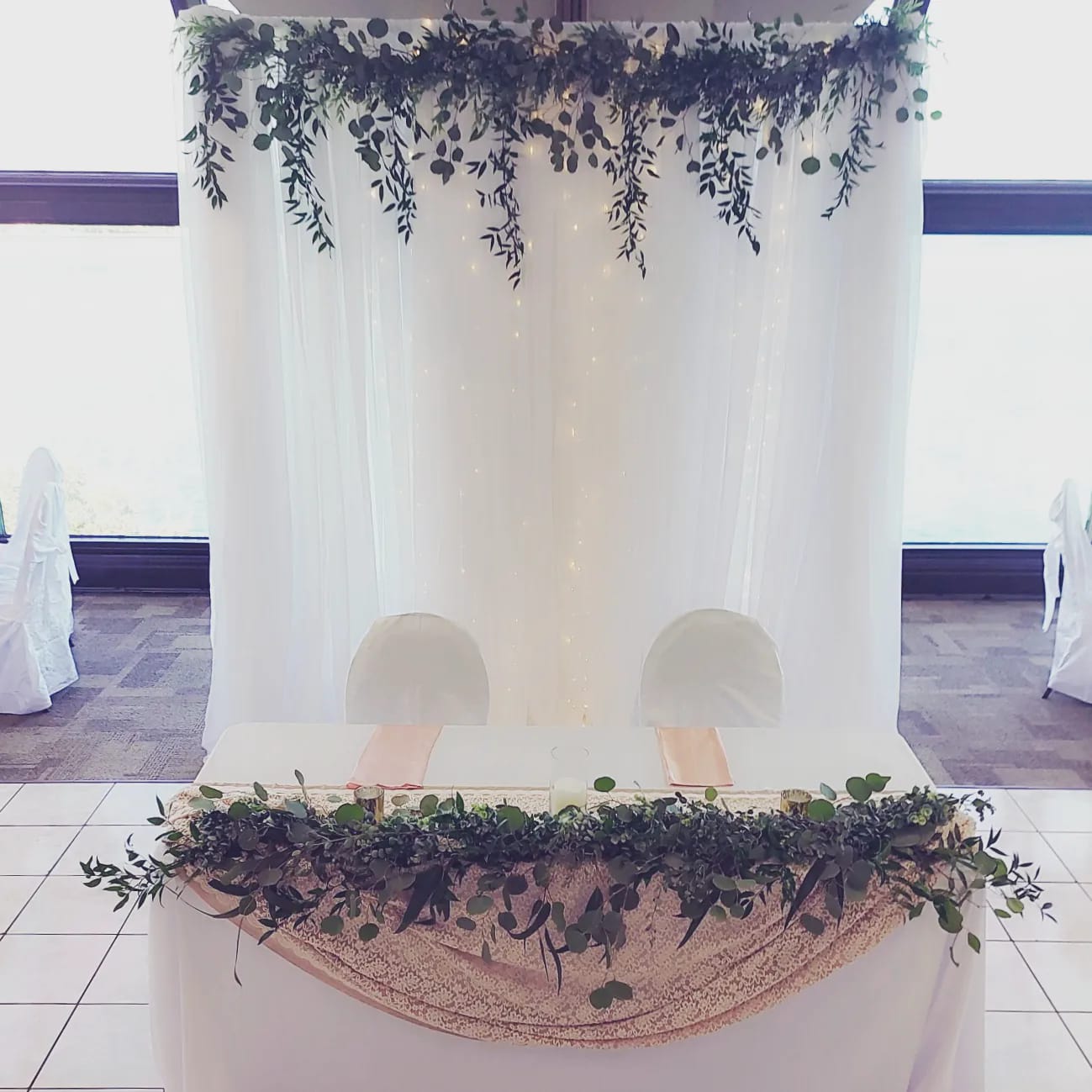 sweetheart table backdrop with trailing eucalyptus