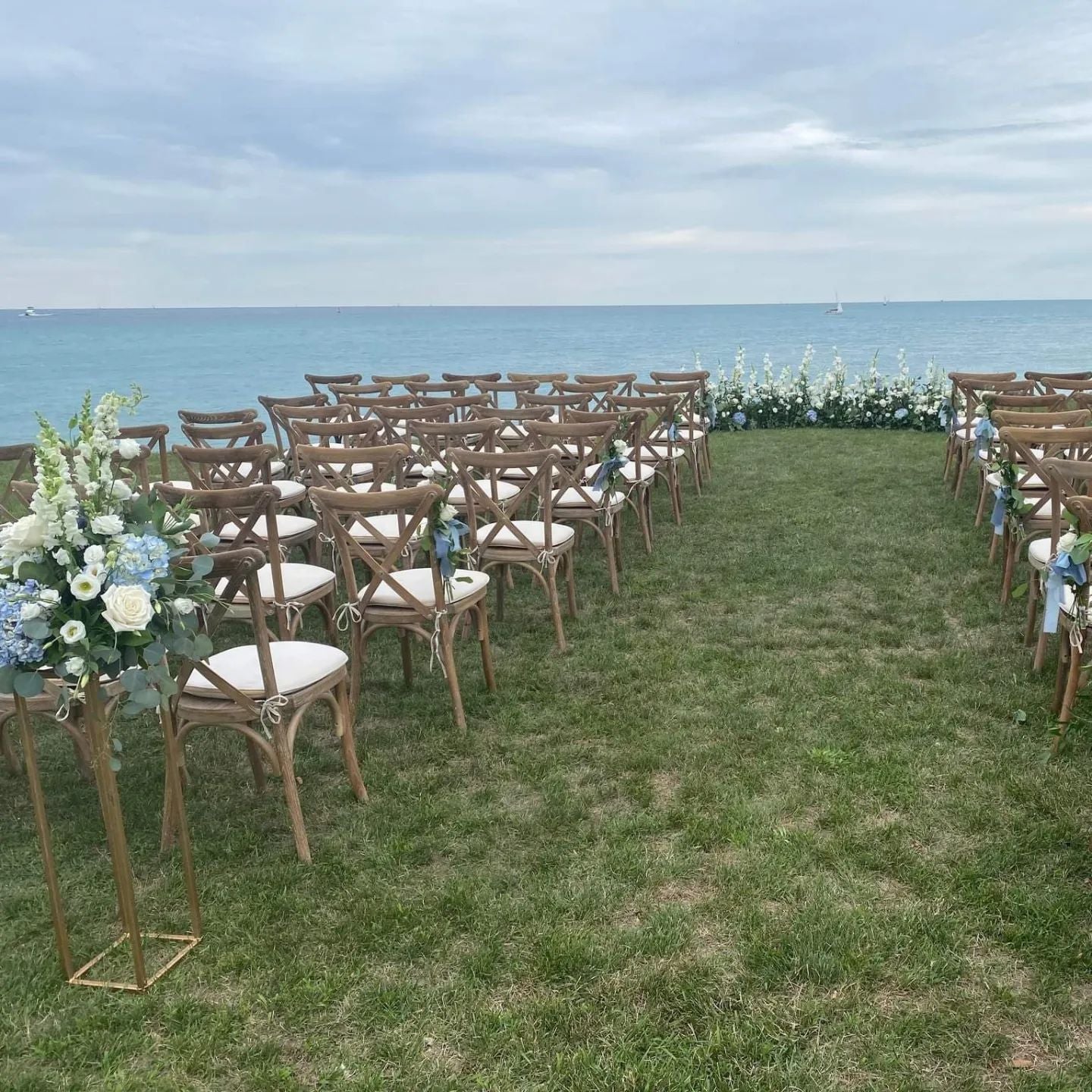wedding ceremony on water with grounded arch and harvest chairs
